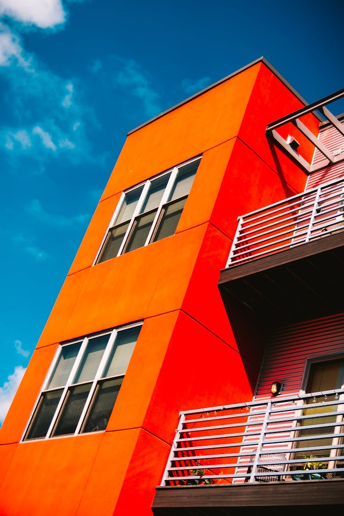 Low-angle Photography of Orange Concrete Building Under Blue and White Sky